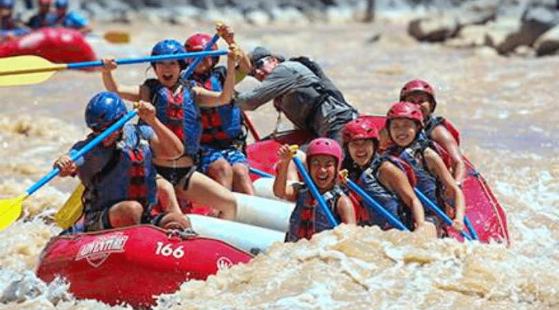 group smiling while whitewater rafting