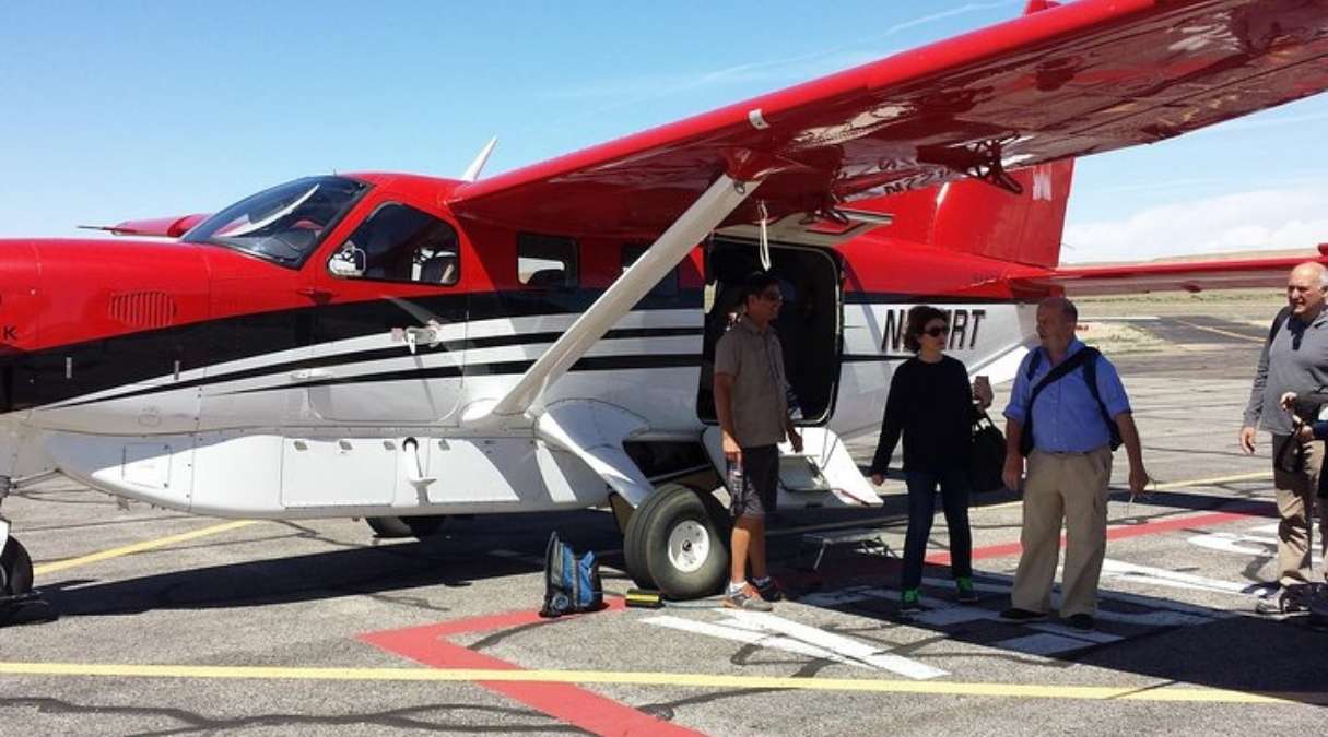 guests loading a red and white airplane before a tour