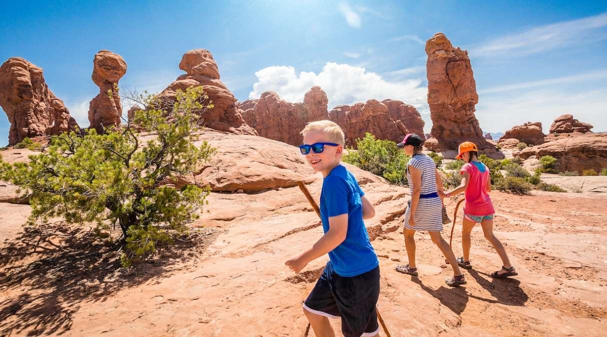 young kid hiking with family in moab