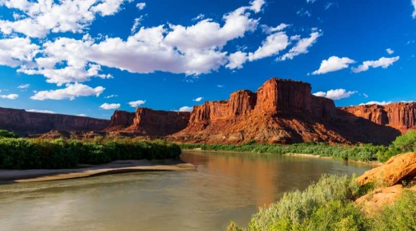 view of the green river and red rock cliffs in canyonlands