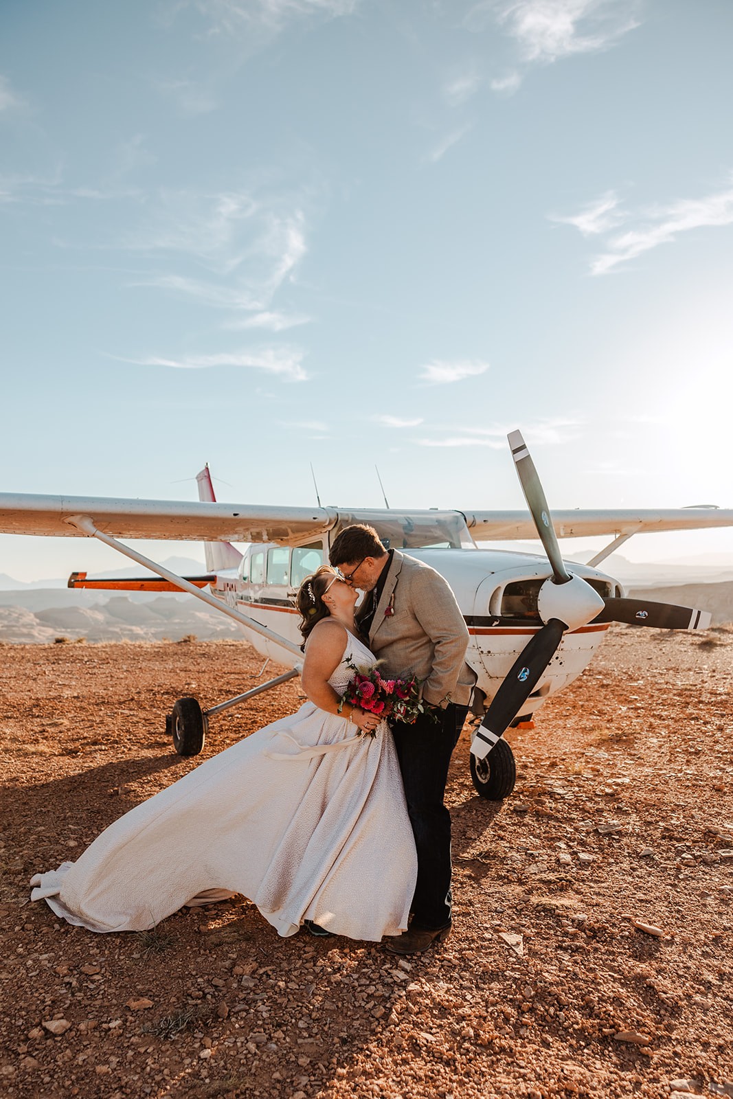 couple kissing in front of airplane during backcountry elopement