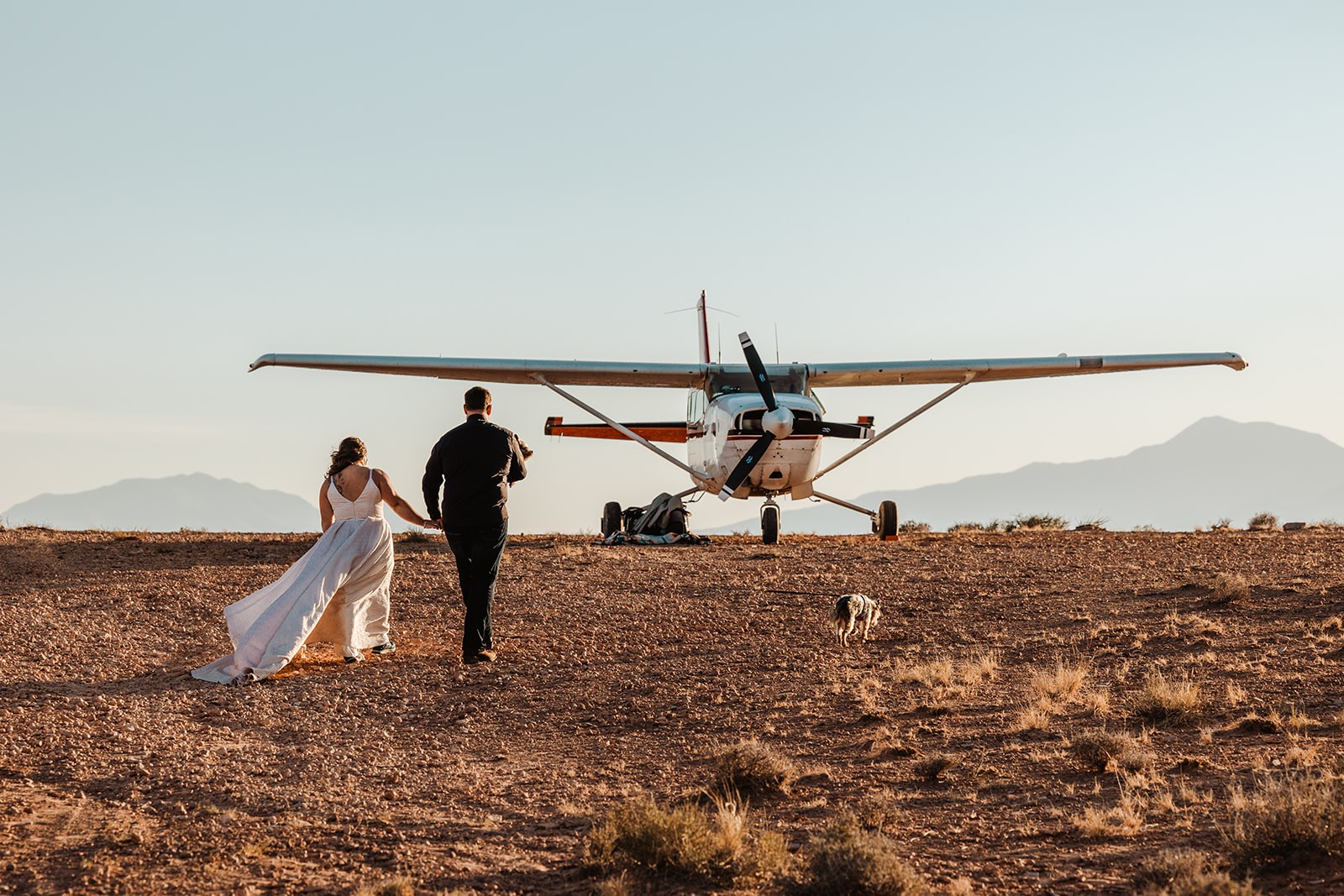 couple walking toward airplane during backcountry elopement