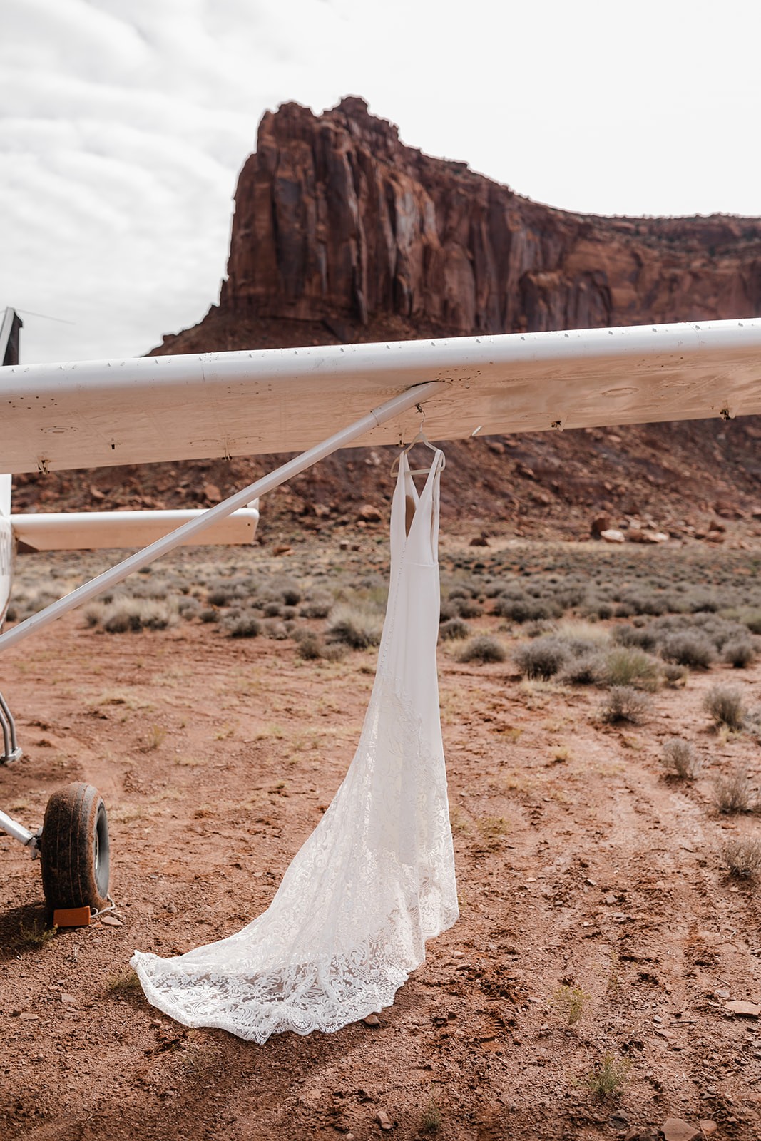 wedding dress hanging on airplane wing