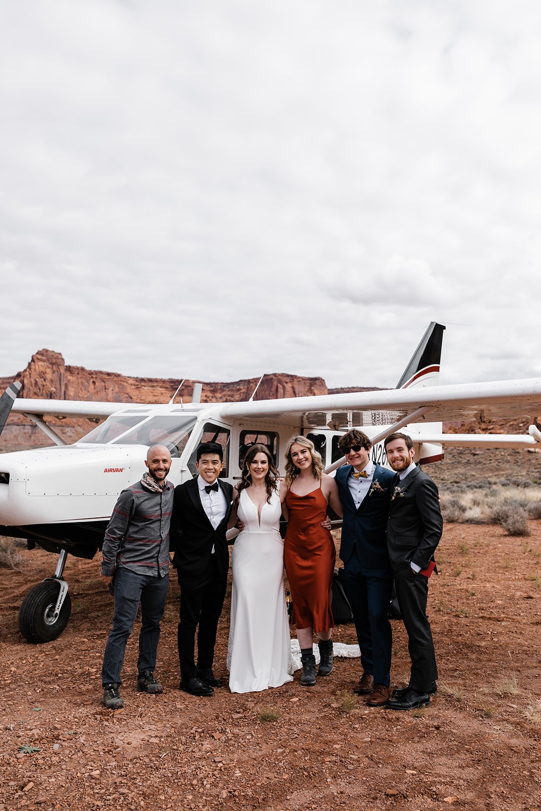 wedding couple and a couple guests pose for a photo with Redtail pilot