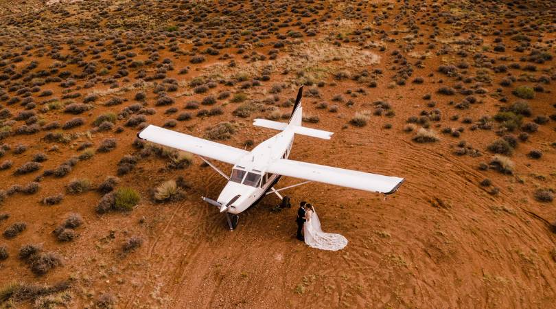 couple next to airplane on an elopement