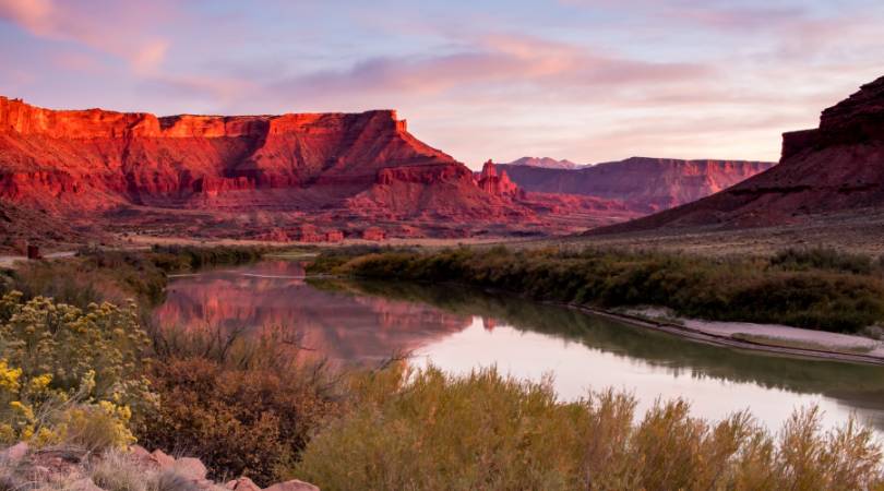 red-lit canyon walls behind a river reflection