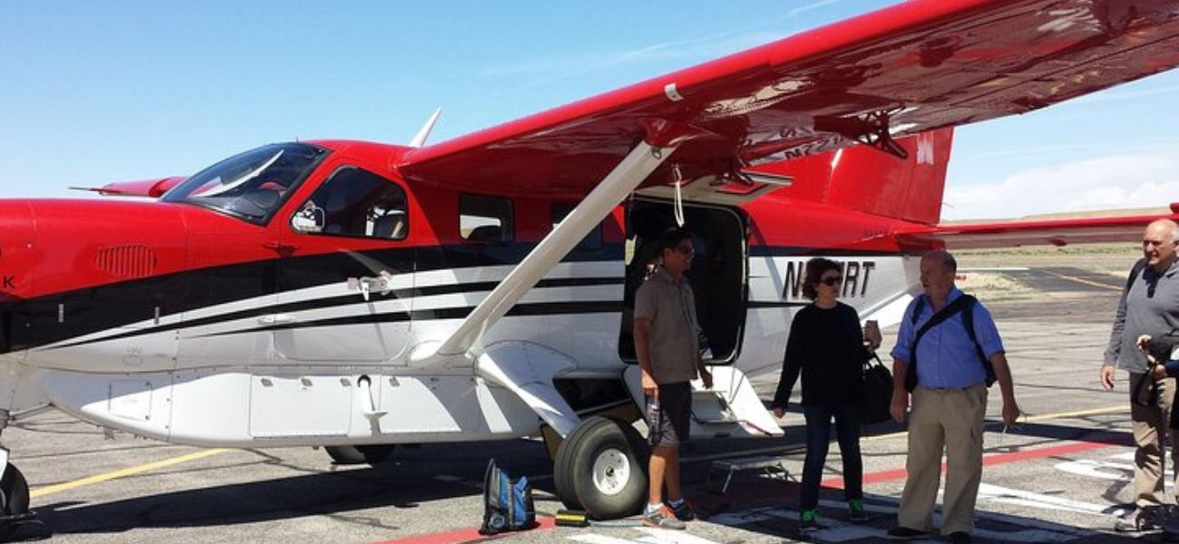 people boarding red and white airplane