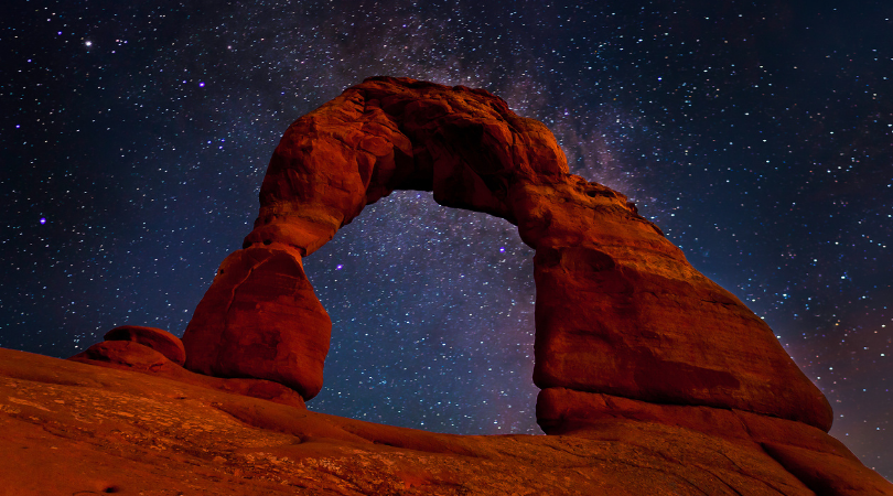 delicate arch in moab at night with a sky full of stars in the background