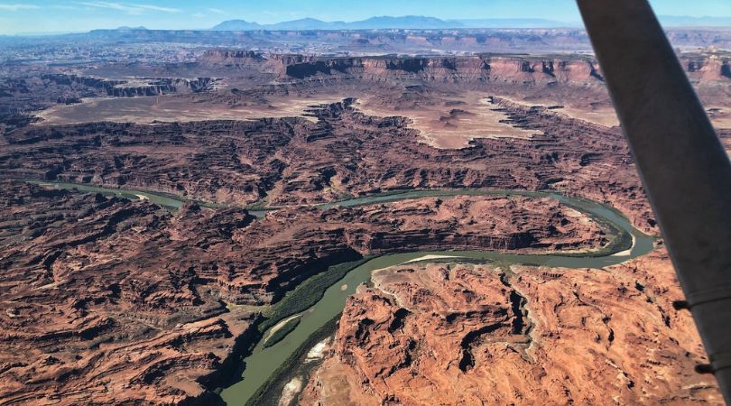 aerial view of a river winding through canyonlands national park from an airplane