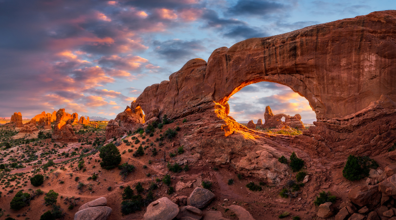 the windows arch in arches national park at sunset with more arches in the background